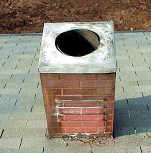 Deteriorating metal oil furnace chimney with faux brick finish