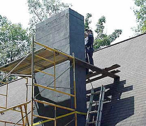 man on scaffold building masonry chimney
