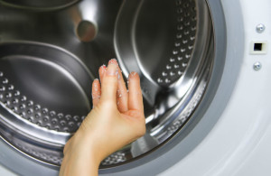 woman with lint in hand with dryer in the background