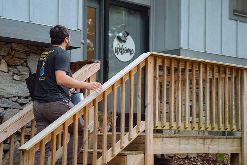 man walking up outdoor stairs to glass door office